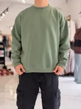 Buzo oversize de cuello redondo en color verde militar, con mangas largas y puños y dobladillo en rib.