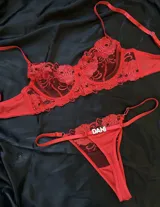 Conjunto de lencería rojo con aro y armado, confeccionado en tul con delicado bordado floral. Incluye soutien de copas semitransparentes y bombacha colaless con tiras regulables y detalle de letras en strass personalizables.
