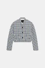 Chaqueta corta de Zara Woman Collection confeccionada en tejido de algodón con estampado de cuadros en tonos blanco, azul y negro. Presenta escote en pico, manga larga y cierre frontal con botones oscuros.