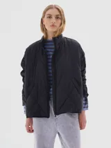 Campera negra acolchada con diseño de rombos, cuello alto y cierre frontal. Es liviana y packable.