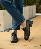 Zapato acordonado de cuero vacuno con acabado desgastado, de horma cuadrada y suela de goma con pequeño taco.