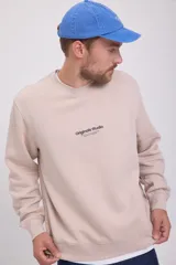 Buzo color beige de manga larga y cuello redondo con logo pequeño en el pecho. Corte relajado y tejido de bucle.