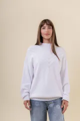 Sweater tejido de punto color blanco, con cuello alto y diseño en relieve tipo chevron en la parte frontal. Presenta un calce holgado con terminaciones acanaladas en puños y ruedo.