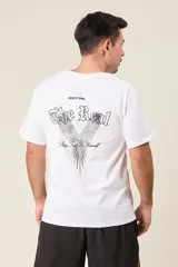 Remera marrón de corte holgado con estampado de un ave y texto en la espalda.