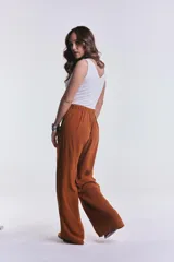 Pantalón camel de pierna ancha y corte recto, con pretina elástica fruncida en la cintura.