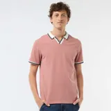 Remera polo de manga corta color rosado, con cuello y ribetes en las mangas de color blanco con líneas negras y azul marino. Presenta diseño con escote en V sin botones.