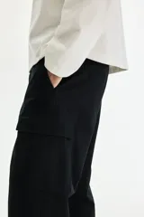 Pantalón cargo negro de sarga de algodón, con bolsillos laterales con solapa en las perneras y corte relajado.