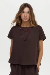 Blusa de lino color blanco, con cuello bote y mangas cortas de corte holgado.