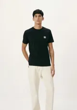 Camiseta de manga corta color negro con cuello redondo y parche con logo de la marca Hering en el pecho.