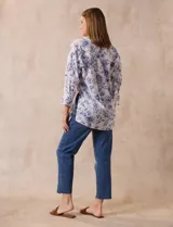Blusa estampada con flores azules sobre fondo blanco, marca Floral & Ivy. Tiene cuello a la base con escote en V y aplique de botones. Las mangas son tres cuartos con puño y botón. Presenta tajos en las costuras laterales.