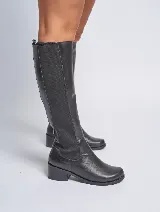 Bota de caña alta confeccionada en cuero vacuno negro, con panel elástico lateral para un ajuste cómodo y taco cuadrado de 4 cm. Cuenta con suela de caucho antideslizante y forro interior de cuero.