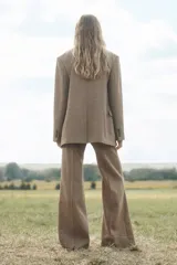 Blazer de lana a cuadros color marrón, con cuello solapa de muescas y manga larga. Tiene bolsillos con solapa en delantero y de vivo en pecho. Cierre frontal cruzado con botones.