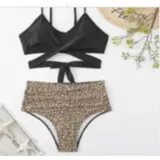 Conjunto de bikini de dos piezas de la marca Uniteduy, compuesto por un crop top amarillo liso con diseño cruzado y tirantes finos, y una bombacha de tiro alto con estampado floral y de hojas en tonos amarillos, verdes y blancos.