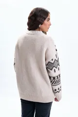 Buzo de punto con diseño de jacquard geométrico en tonos beige y marrón oscuro, cuello redondo y puños acanalados.