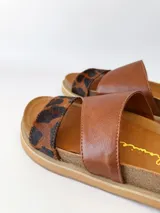 Sandalias bajas de cuero marrón con estampado animal print en las tiras.