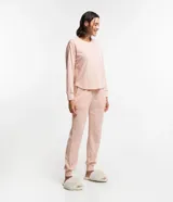 Conjunto de pijama largo color rosa claro texturizado, compuesto por un buzo de cuello redondo y un pantalón con cintura con lazo.