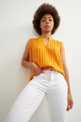 Pantalón de corte slim en color blanco, confeccionado en denim, con cierre frontal de botón y cremallera, y bolsillos laterales.