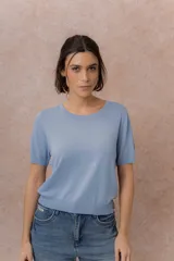 Remera tejida fina de color celeste, de manga corta, con cuello redondo y terminaciones en rib en el cuello, mangas y ruedo.