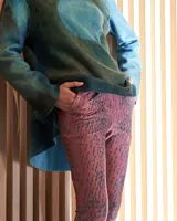 Pantalón de satén lycra color fucsia con estampado abstracto color ocre, corte elevado, bolsillos laterales y pretina ancha flexible.