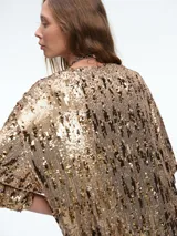Vestido corto de corte recto y holgado, confeccionado en tejido cubierto de lentejuelas doradas. Presenta cuello redondo, mangas cortas amplias y una caída fluida.