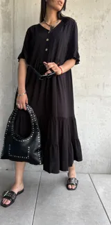 Vestido midi negro con botones frontales, mangas cortas con volados y falda con volados escalonados.