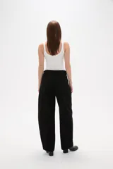 Pantalon jean de corte barrel y tiro medio, en color negro, con diseño de pierna ancha y estructura rígida.