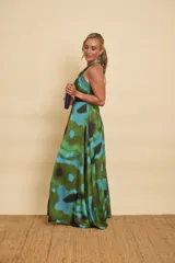 Vestido largo de satén con estampado abstracto en tonos verdes, azules y negros, escote halter y diseño fluido.