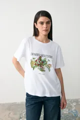 Remera blanca de algodón con cuello redondo y mangas cortas. Presenta una estampa botánica central con el texto 'DIARIO SILVESTRE' en tipografía clásica.