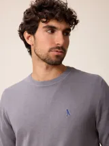 Sweater de punto con cuello redondo, manga larga y puños acanalados. Presenta un pequeño logo bordado en el pecho.
