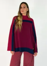 Sweater de punto con diseño de bloques de color en tonos marrón, chocolate y bordó, de cuello alto y corte holgado.