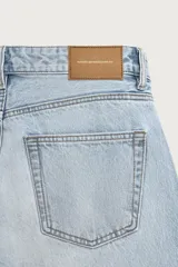 Jeans regular fit de mezclilla celeste con efecto lavado, corte recto y diseño clásico de cinco bolsillos. Cuenta con cierre frontal de botones.