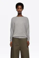 Camiseta de modal y poliéster color gris melange, con escote barco, mangas ranglán estilo murciélago y puños largos ajustados.