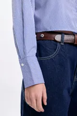 Camisa cropped de mangas largas con puños abotonados, de corte holgado y con estampado de rayas verticales azules y blancas.