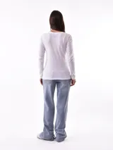 Remera negra de manga larga con escote en V y estampa frontal blanca con diseño de soles y la frase 'Woke Up'.