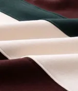 Saco de algodón con diseño de bloques de color en tonos marrón, verde y blanco. Presenta cuello polo con cierre de botones y mangas largas.