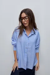 Camisa de manga larga con diseño de rayas verticales blancas y verdes, calce relajado, cuello clásico y botonadura frontal con botones perlados.
