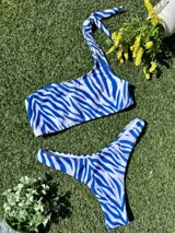 Conjunto de bikini con estampado de cebra en tonos azul y blanco. El corpiño es de un hombro y la bombacha es colaless.