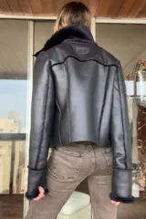 Campera reversible de corte recto y largo a la cadera. Un lado presenta un acabado de napa negra, mientras que el otro lado está confeccionado en piel sintética de color azul noche, extremadamente suave al tacto. Cuenta con mangas largas y un diseño versátil y elegante.