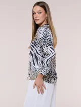 Blusa de gasa liviana con estampado animal print que combina leopardo y cebra, cuello camisero con escote en V y mangas largas con puños anchos.