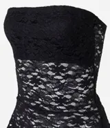 Blusa strapless confeccionada en encaje negro con diseño de bajo asimétrico con puntas diferenciadas. Presenta escote recto y forro interior.