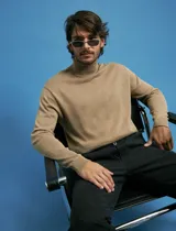 Polera de punto de manga larga en color azul marino, con cuello alto doblado y puños y ruedo acanalados.