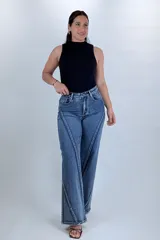 Pantalón jean wide leg de tiro alto en color azul, con diseño de costuras diagonales contrastantes en el frente y corte amplio en las piernas.