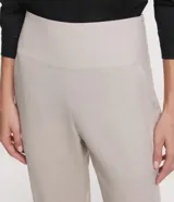 Pantalón negro de lino, corte carrot, con cintura ancha y pliegues en el bajo.