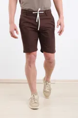 Bermuda de gabardina color marrón, con cintura elástica y cordón ajustable, bolsillos laterales y corte recto.