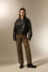 Campera de eco-cuero color negro, con cuello clásico, cierre frontal y puños con elástico. Presenta un diseño de corte holgado con costuras verticales decorativas.