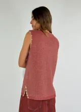 Chaleco tejido de punto color ladrillo, con escote en V y terminaciones desflecadas.