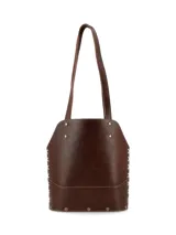 Matera de cuero color marrón con diseño estructurado, costuras laterales decorativas en color claro, base reforzada con remaches metálicos y detalle de borla colgante. Incluye correas largas para llevar al hombro.