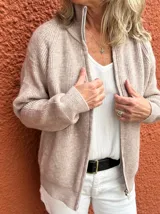 Campera de tejido de punto en color beige melange, con cierre frontal completo, cuello alto y mangas largas con puños acanalados.