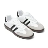 Championes Adidas Samba blancos con las tres tiras laterales negras, puntera de gamuza gris y suela marrón.