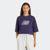 Remera de corte cropped y diseño holgado, color violeta, con cuello redondo y mangas cortas. Presenta un estampado gráfico frontal con el logo de New Balance con textura de encaje.